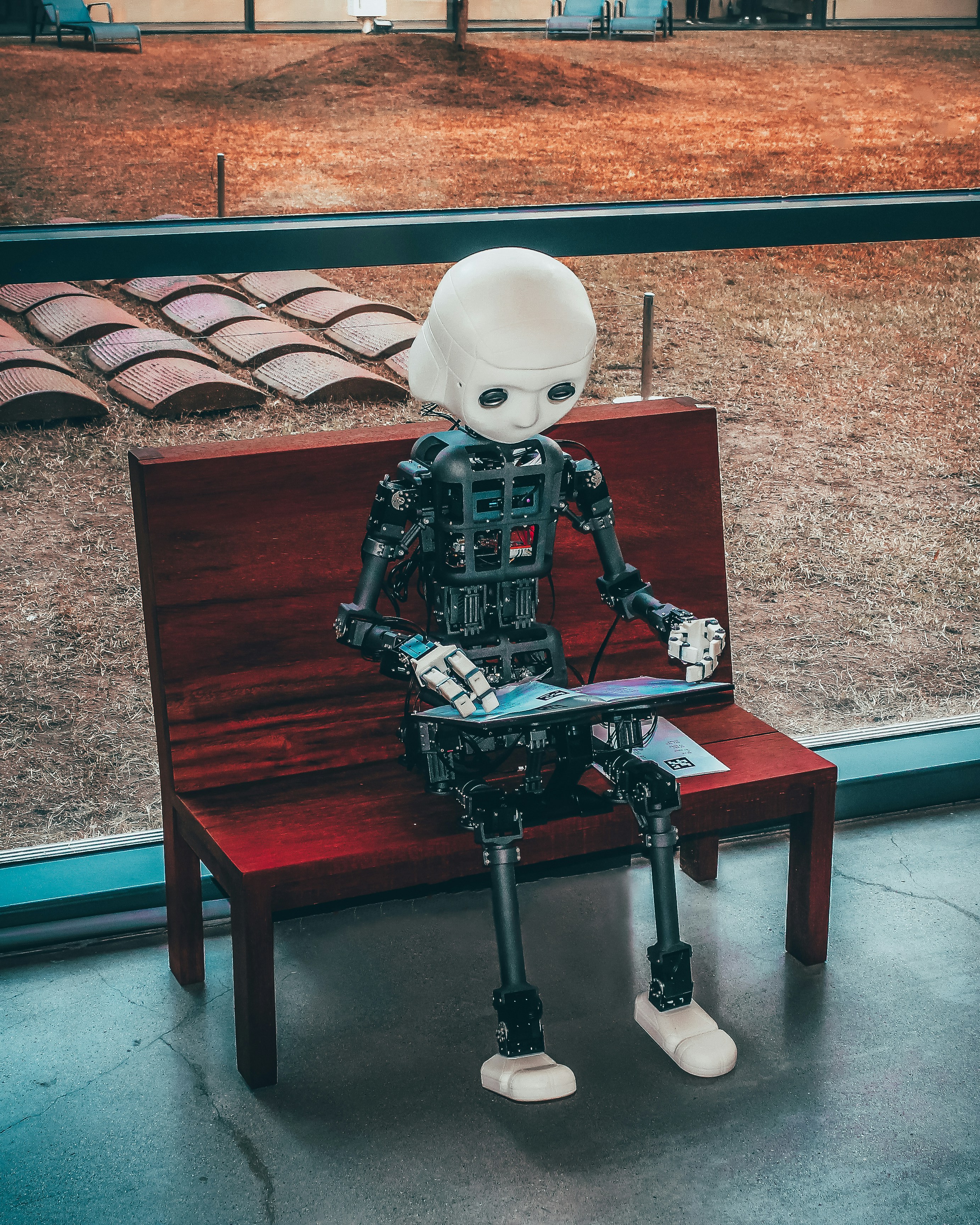 black and white robot toy on red wooden table black and white robot toy on red wooden table